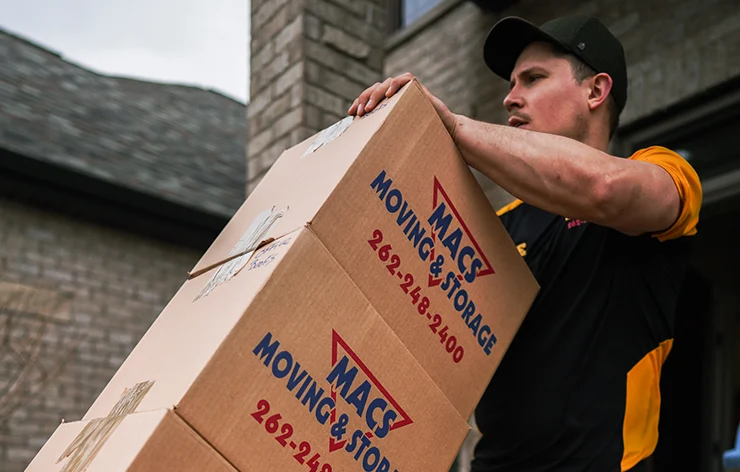 MACs Moving and Storage mover carrying branded moving boxes outside a Lake Geneva, WI home