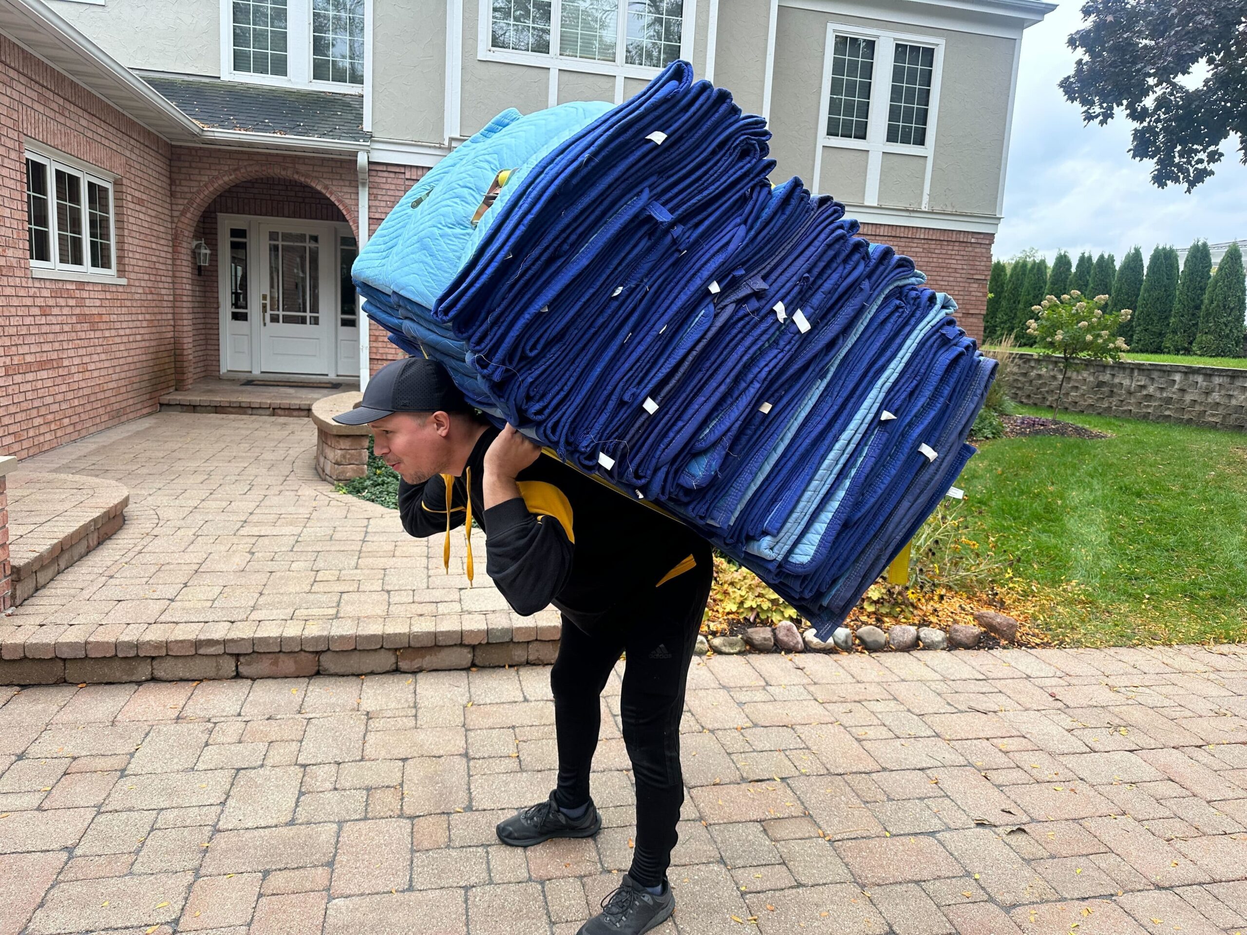MACs Moving and Storage mover carrying professional moving blankets at a Southeast Wisconsin residential move