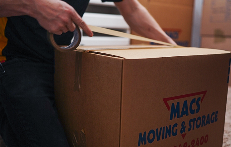MACs Moving and Storage packer sealing a moving box during professional packing services in Wisconsin