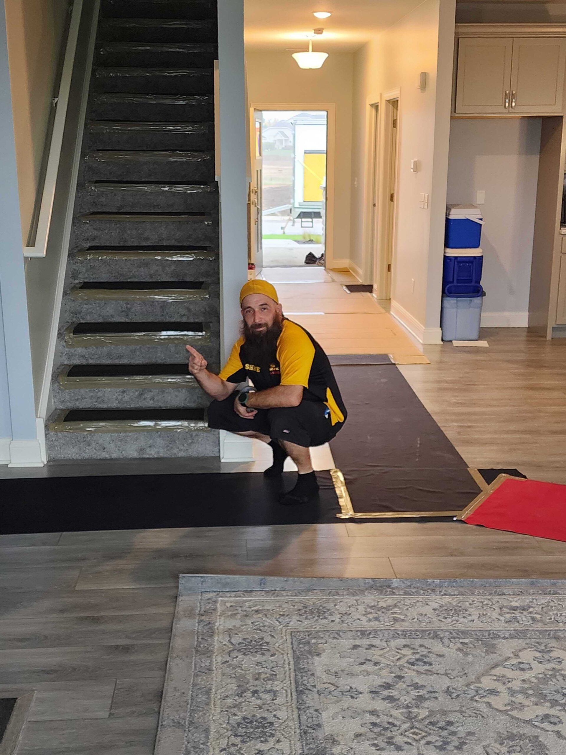 MACs Moving and Storage mover laying floor protection runners before a Lake Geneva residential move