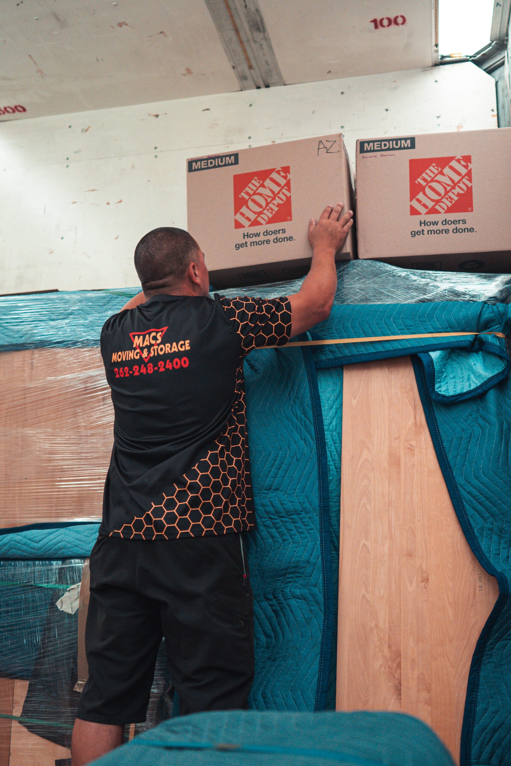 macs long distance movers stacking boxes inside truck